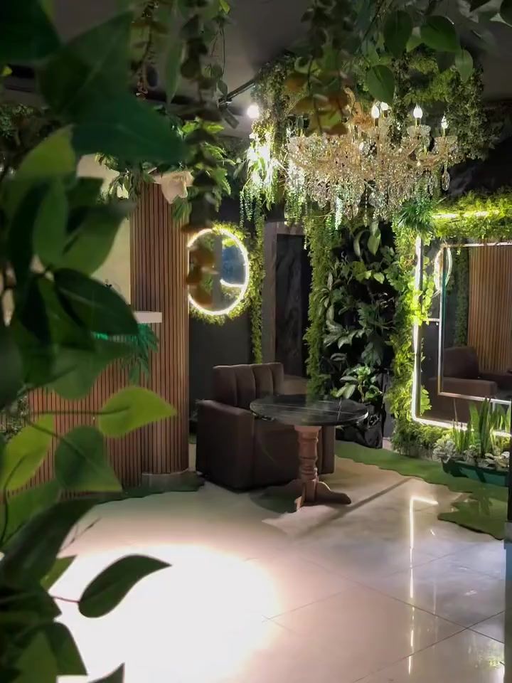 Sala de Selva Negra con una lámpara de cristal y un espejo con aro de luz, entre plantas